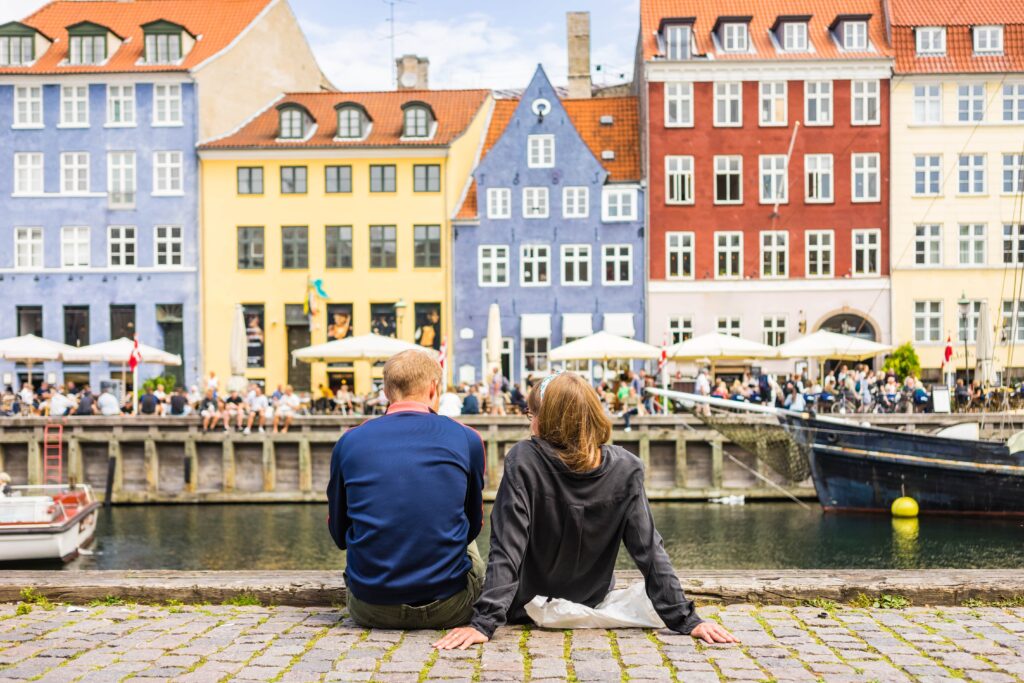 Denmark | Smartferry | Tourists enjoying the scenic summer view of Nyhavn pier.