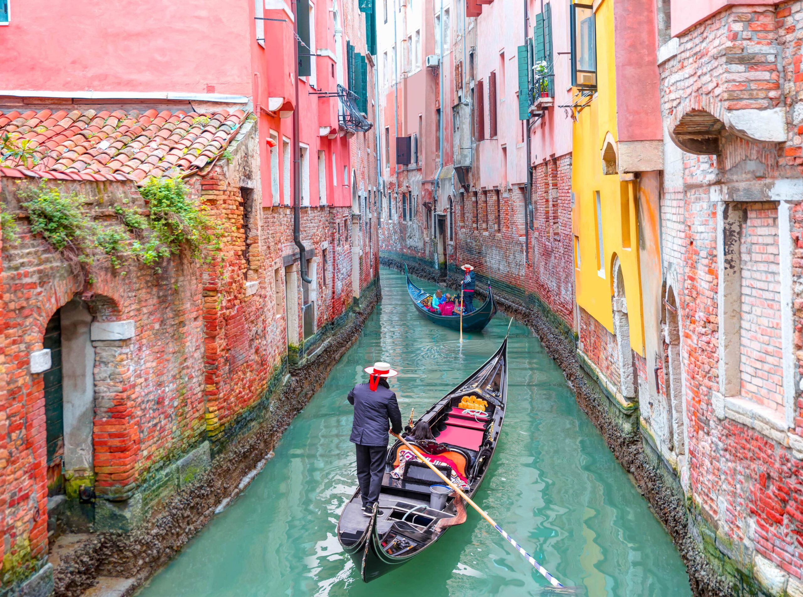 Italy | Smartferry | Venetian gondolier punting gondola through green canal waters of Venice Italy scaled