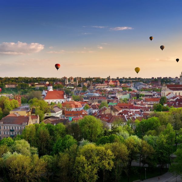 Beautiful summer panorama of Vilnius old town with colorful hot air balloons in the sky